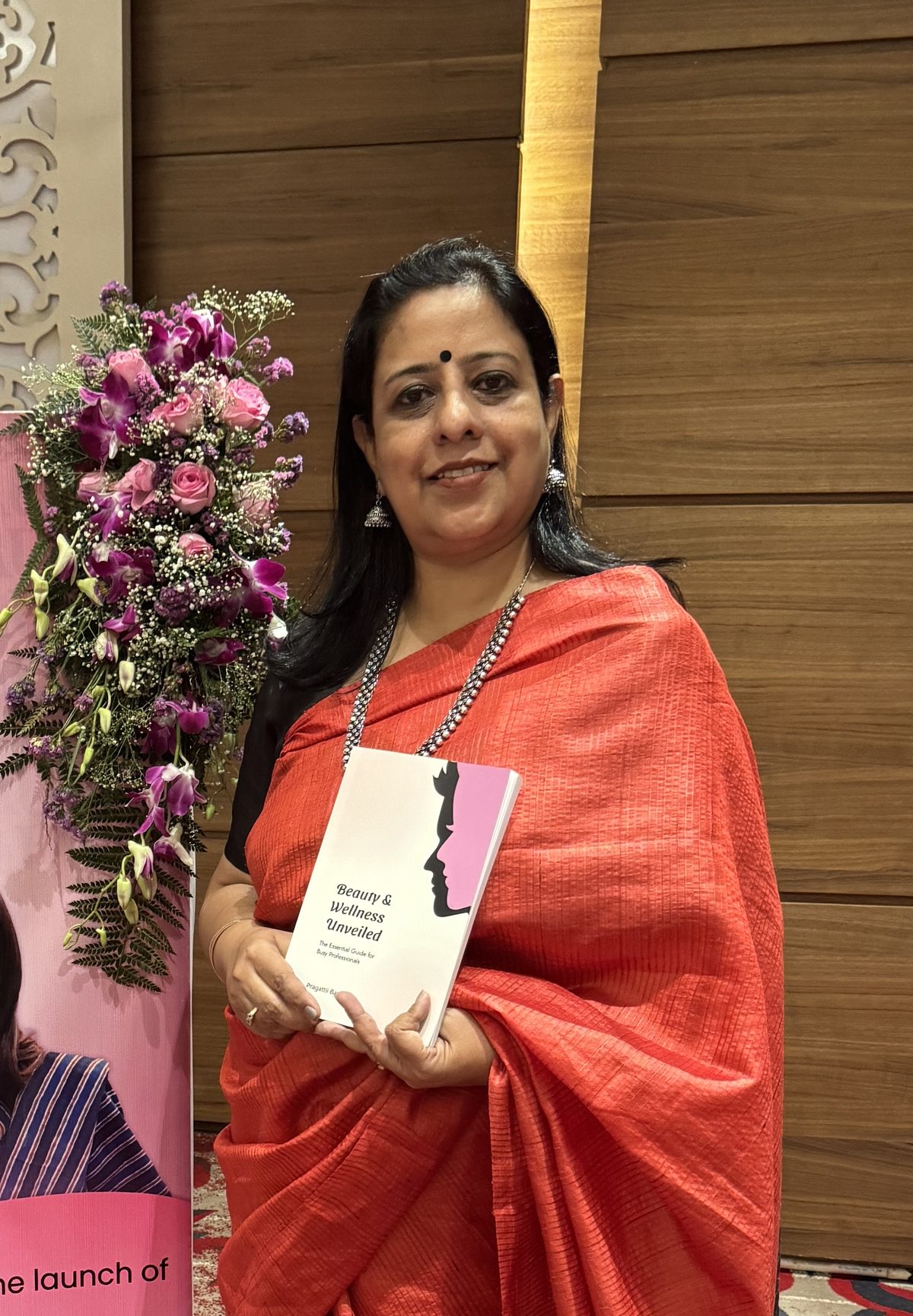 Meenakshi Narang holding a book at a launch event